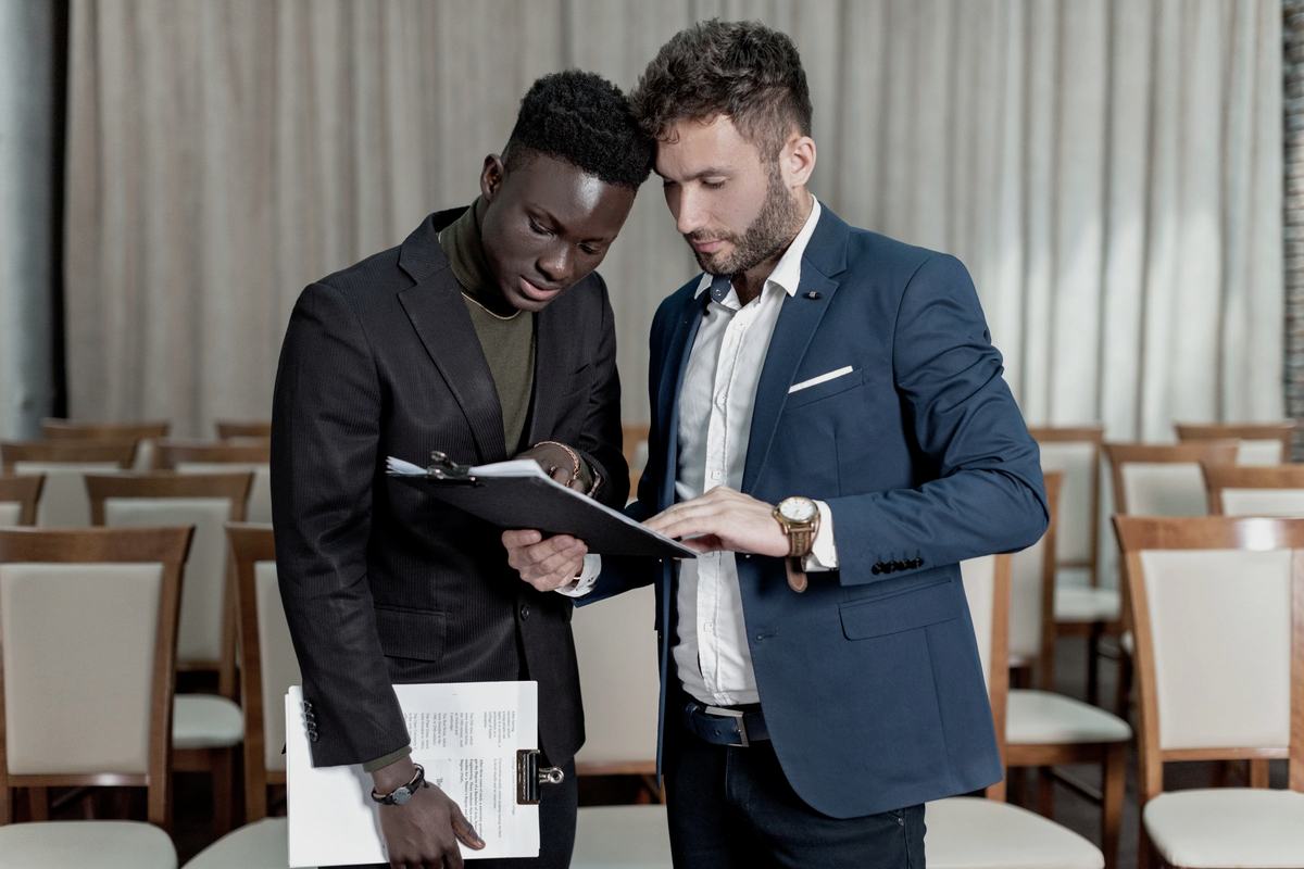 Two professionals reviewing a document together on a clipboard