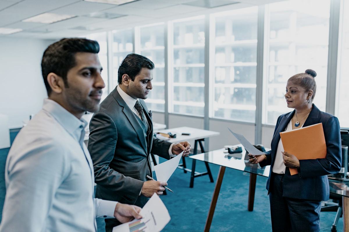 Two professionals discussing printed reports in a working office